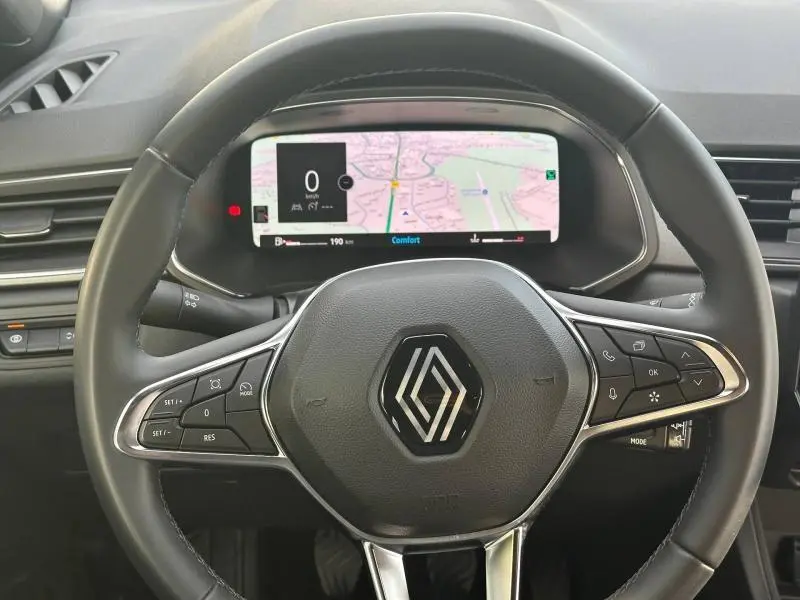 Vue rapprochée du volant Renault Captur 2025 avec tableau de bord numérique affichant une carte de navigation.