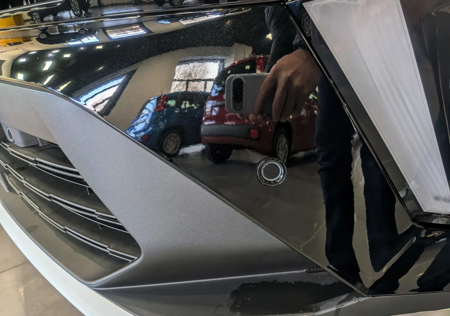 Gros plan sur la calandre avant noire étoilée du Renault Symbioz E-Tech 160 ch avec capteur de stationnement visible.