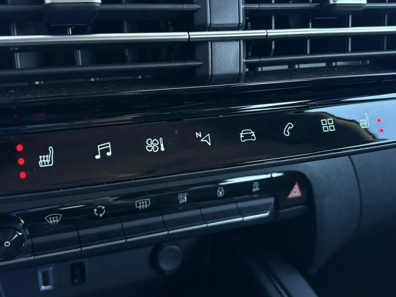 Détail du tableau de bord noir du Citroën C5 Aircross Hybrid 2025 avec commandes tactiles et voyants rouges allumés.