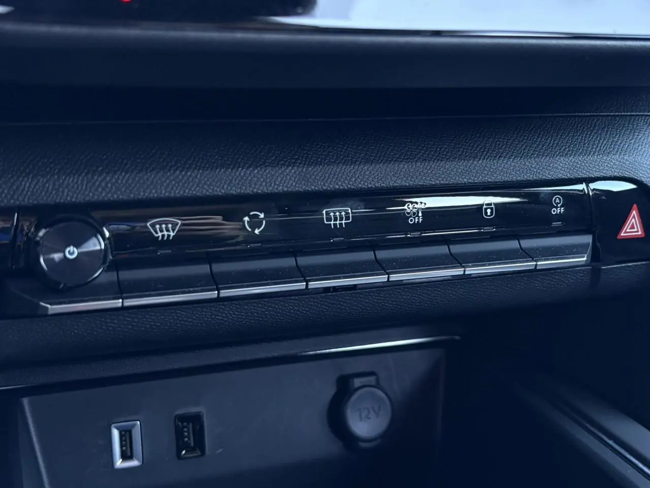 Gros plan sur la console centrale noire du Citroën C5 Aircross Hybrid avec commandes climatisation et prises USB visibles.
