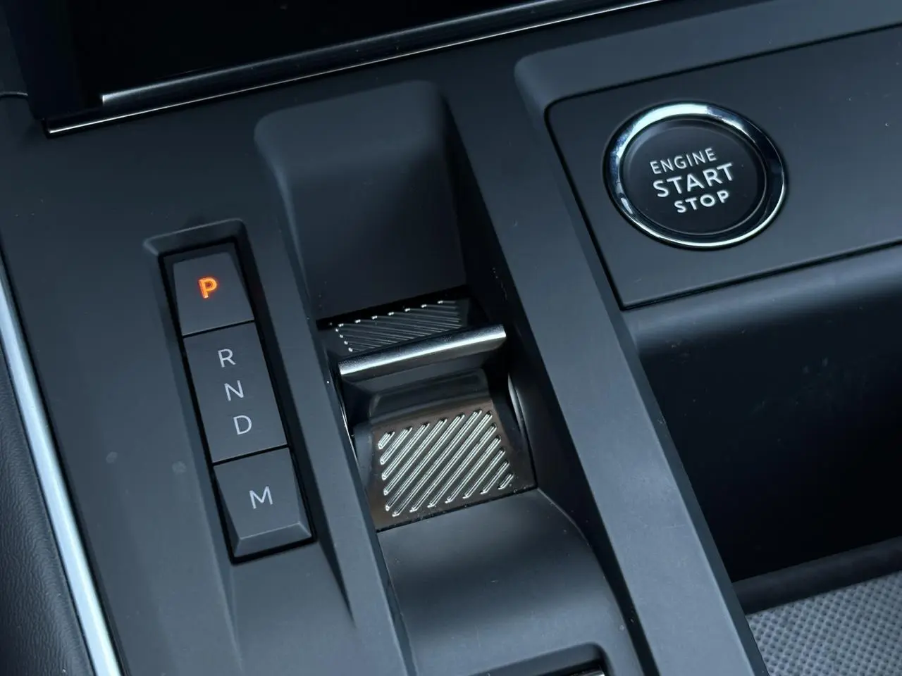 Gros plan sur la console centrale noire du Citroën C5 Aircross Hybrid avec bouton start/stop et sélecteur de boîte automatique.