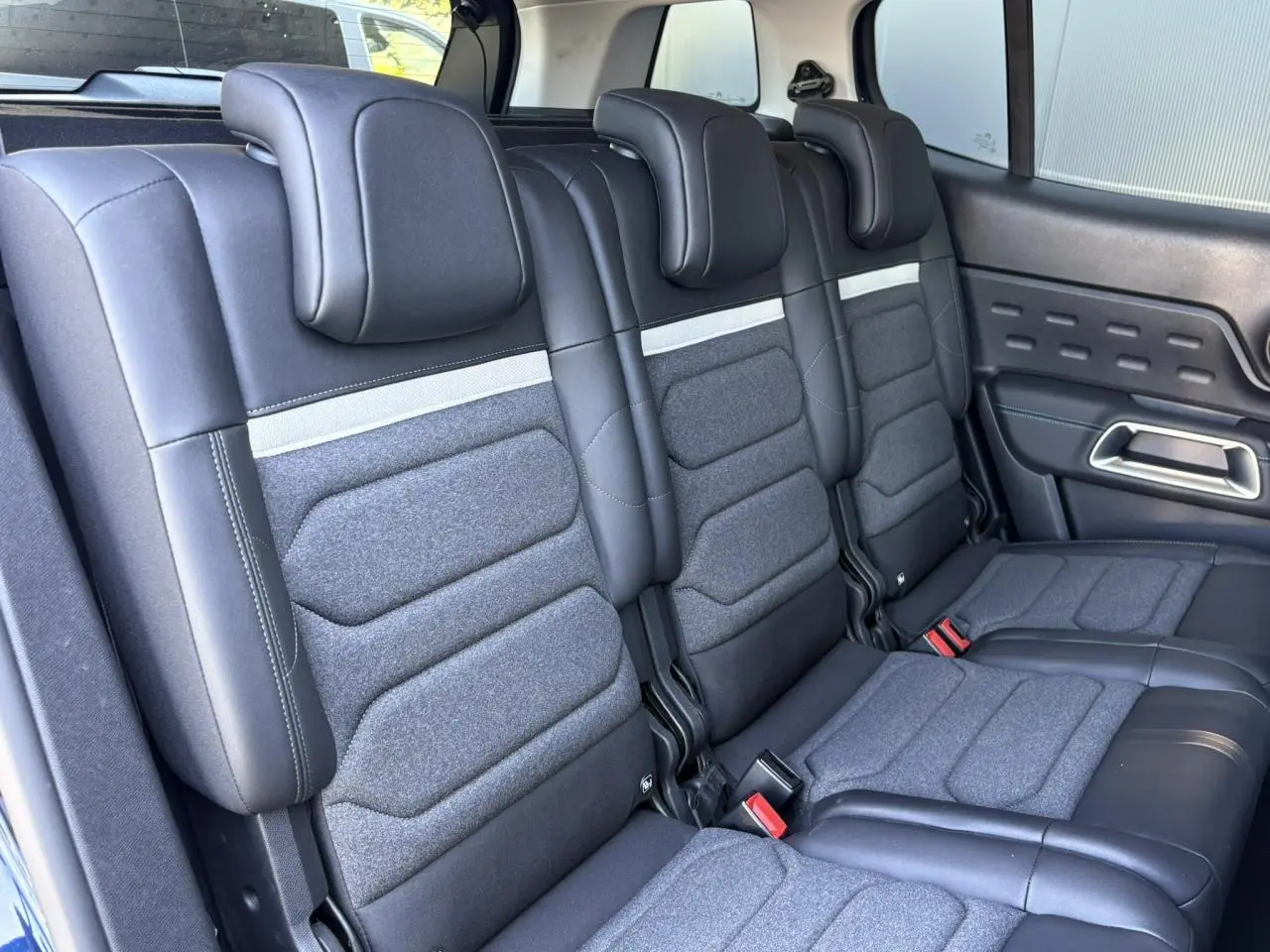 Vue rapprochée des trois sièges arrière indépendants en tissu et cuir noir du Citroën C5 Aircross Hybrid 2025.