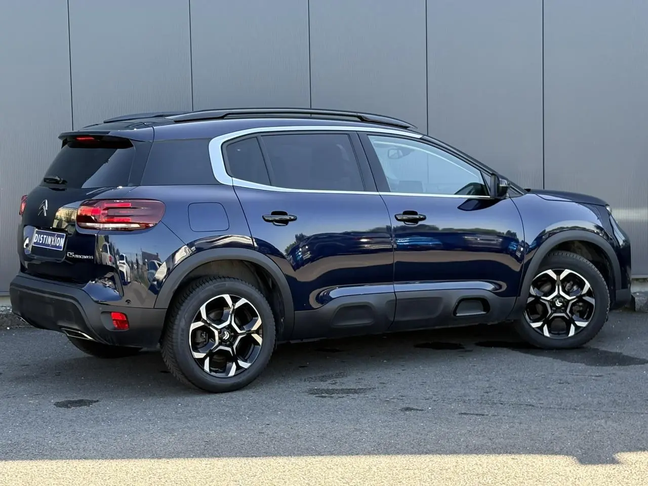 Vue latérale droite d'un Citroën C5 Aircross Hybrid bleu Eclipse avec jantes alliage bi-ton et vitres surteintées.