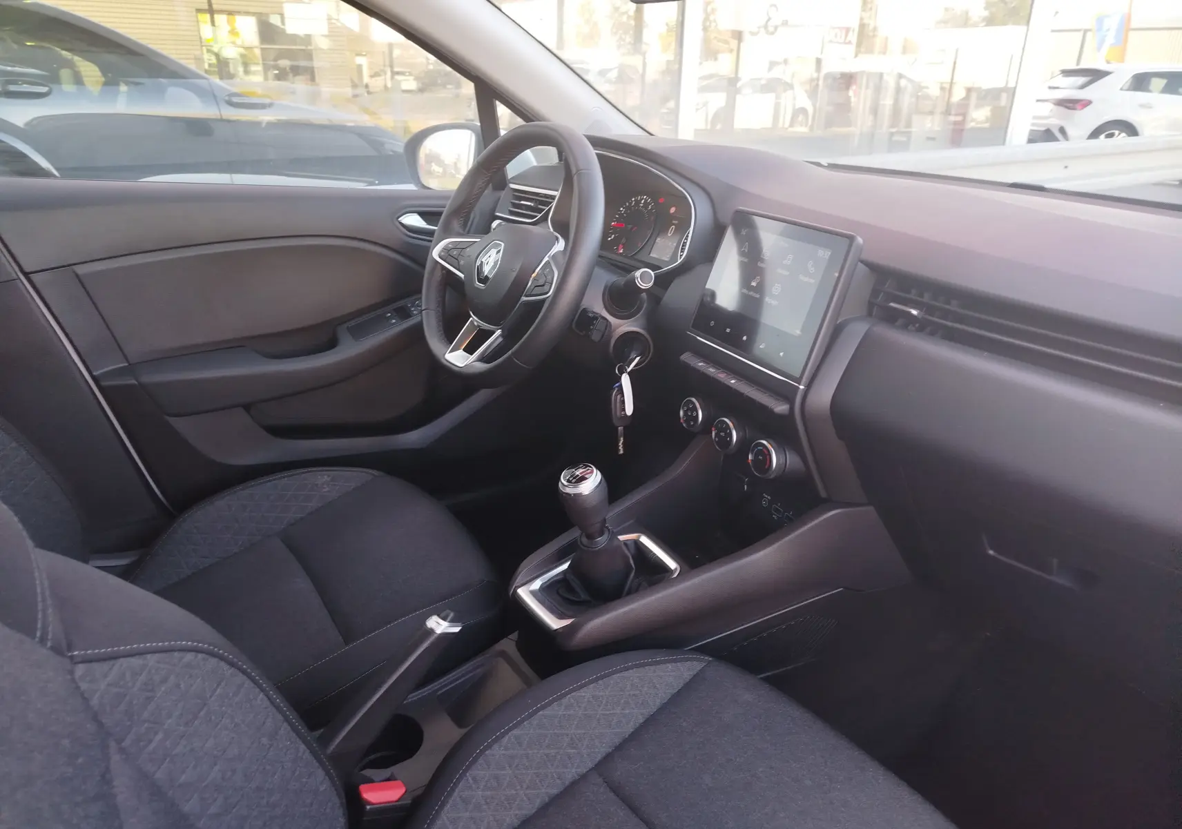 Intérieur de Renault Clio Business 2021 vue côté conducteur, tableau de bord noir avec écran tactile et boîte manuelle.