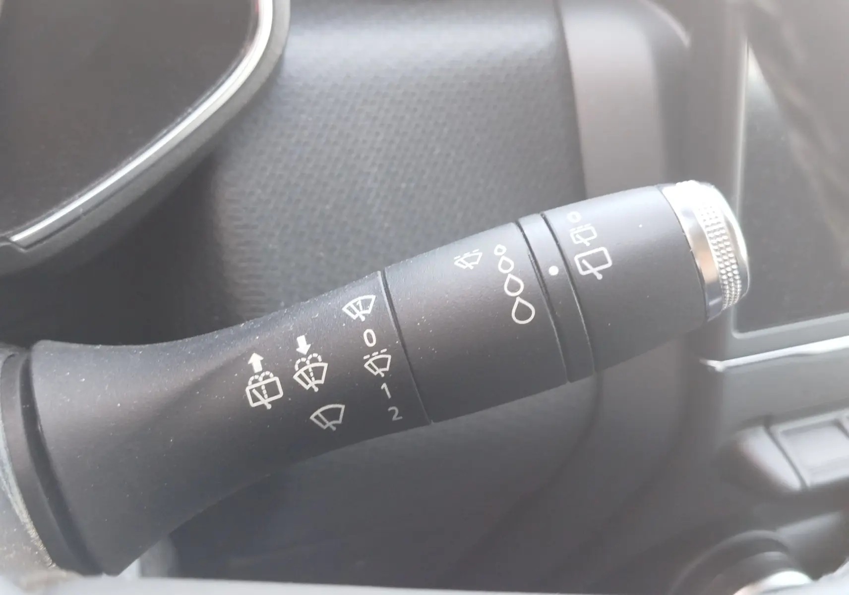 Gros plan sur la commande des essuie-glaces dans l’habitacle d’une Renault Clio blanche Business 2021, version essence.