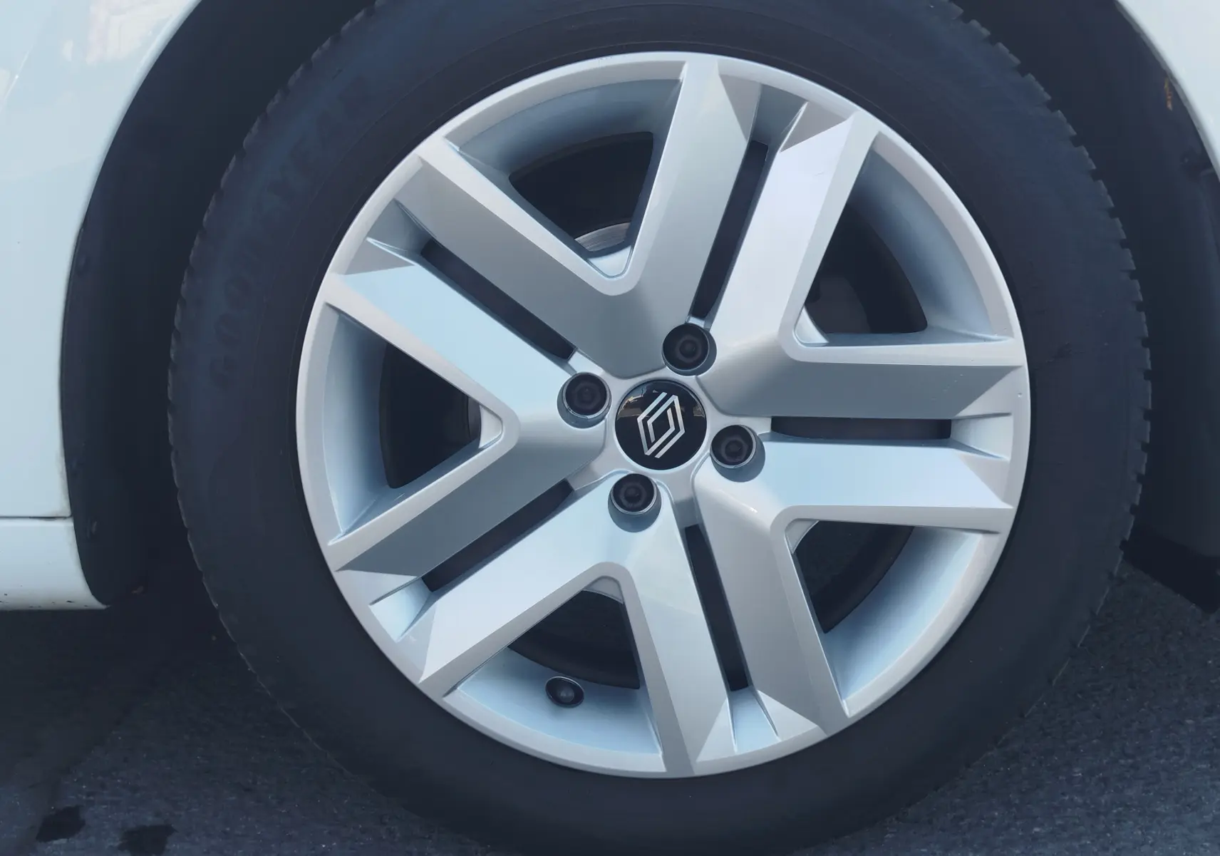 Gros plan sur la jante alliage argentée avec logo Renault, roue avant gauche d'une Renault Clio blanche 2021.
