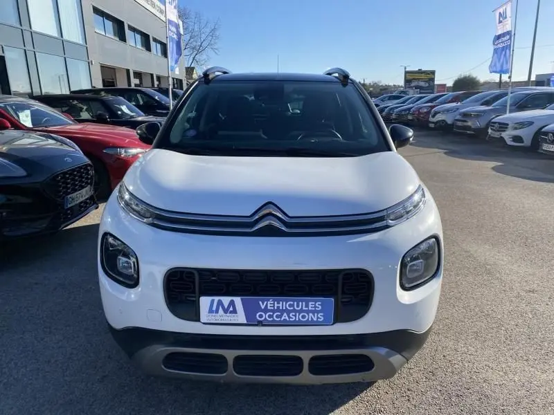 Citroën C3 Aircross blanc en vue frontale, mettant en valeur sa calandre distinctive et ses feux ronds.