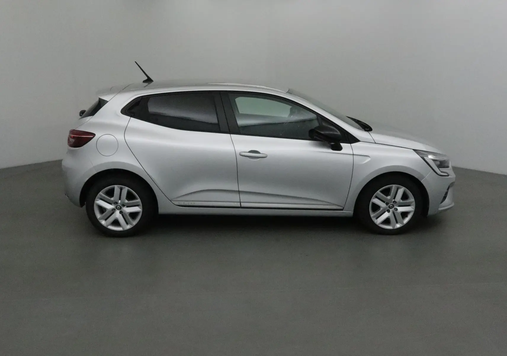 Profil côté gauche d'une Renault Clio V gris platine 2021, compacte avec jantes alliage et vitres teintées.