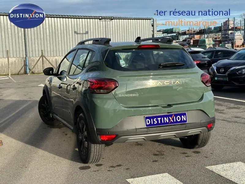 Vue 3/4 arrière droite d'une Dacia Sandero Stepway 2025 en kaki lichen avec toit noir et jantes noires.