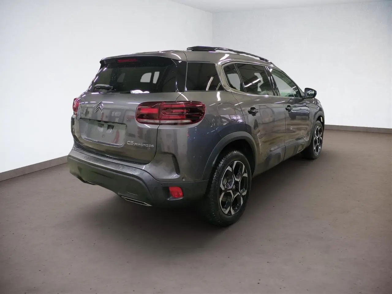 Vue 3/4 arrière droite du Citroën C5 Aircross Hybrid gris Platinium avec jantes alliage et feux arrière LED 3D.