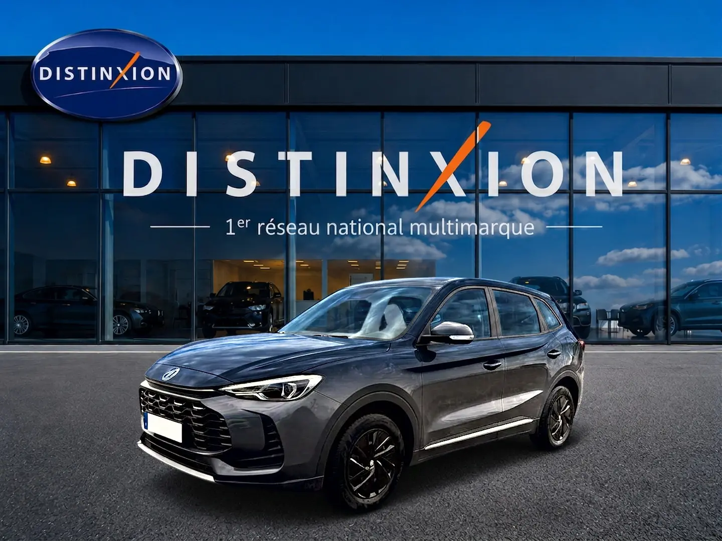 MG Motor ZS 1.5 hybrid 197 Camden grey en 3/4 avant droit, avec jantes noires et calandre marquée.