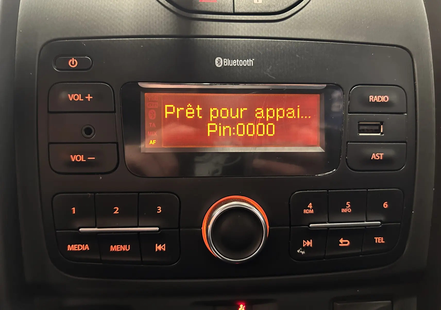 Gros plan sur la console centrale noire du Dacia Duster gris 2017, affichant l'écran radio Bluetooth prêt pour appairage.