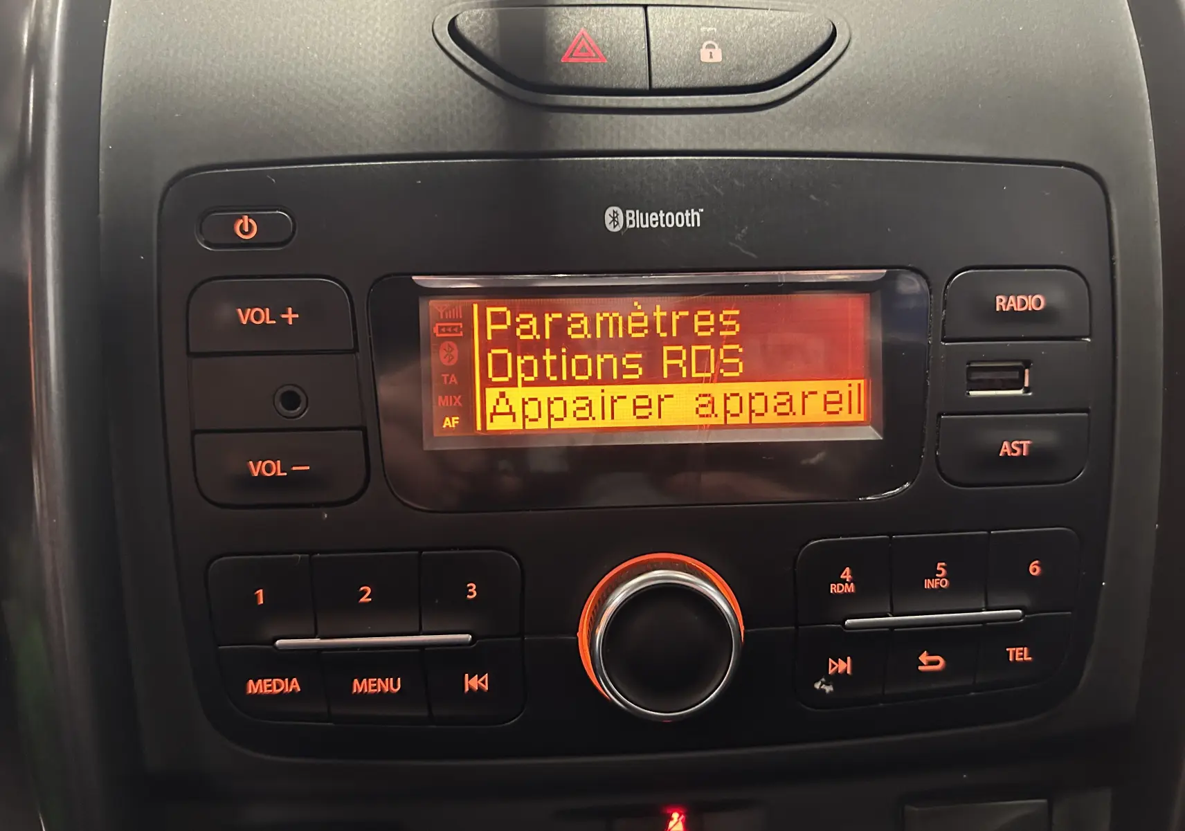 Gros plan sur la console centrale du Dacia Duster gris 2017, affichant le menu Bluetooth et commandes audio.