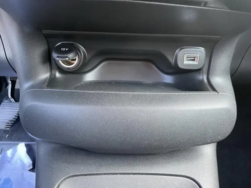 Prise 12V et port USB intégrés dans la console centrale noire du Citroën C4 Cactus gris foncé 2019, version HDI 100 Feel.