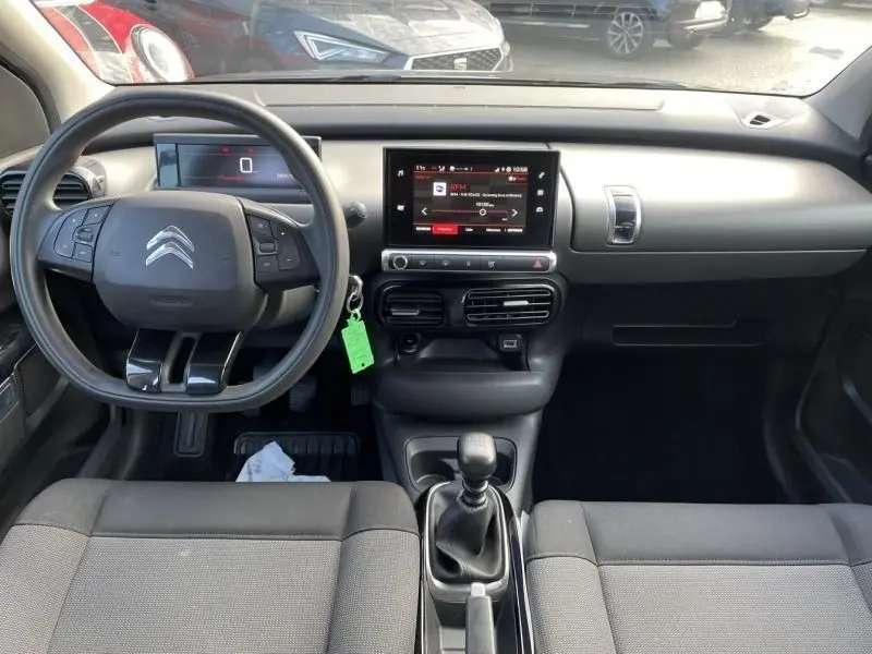 Vue intérieure avant du tableau de bord d'une Citroën C4 Cactus gris foncé 2019 avec boîte manuelle et écran tactile central.