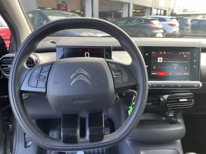 Vue intérieure centrée sur le volant et le tableau de bord d'une Citroën C4 Cactus gris foncé 2019, version HDI 100 Feel.