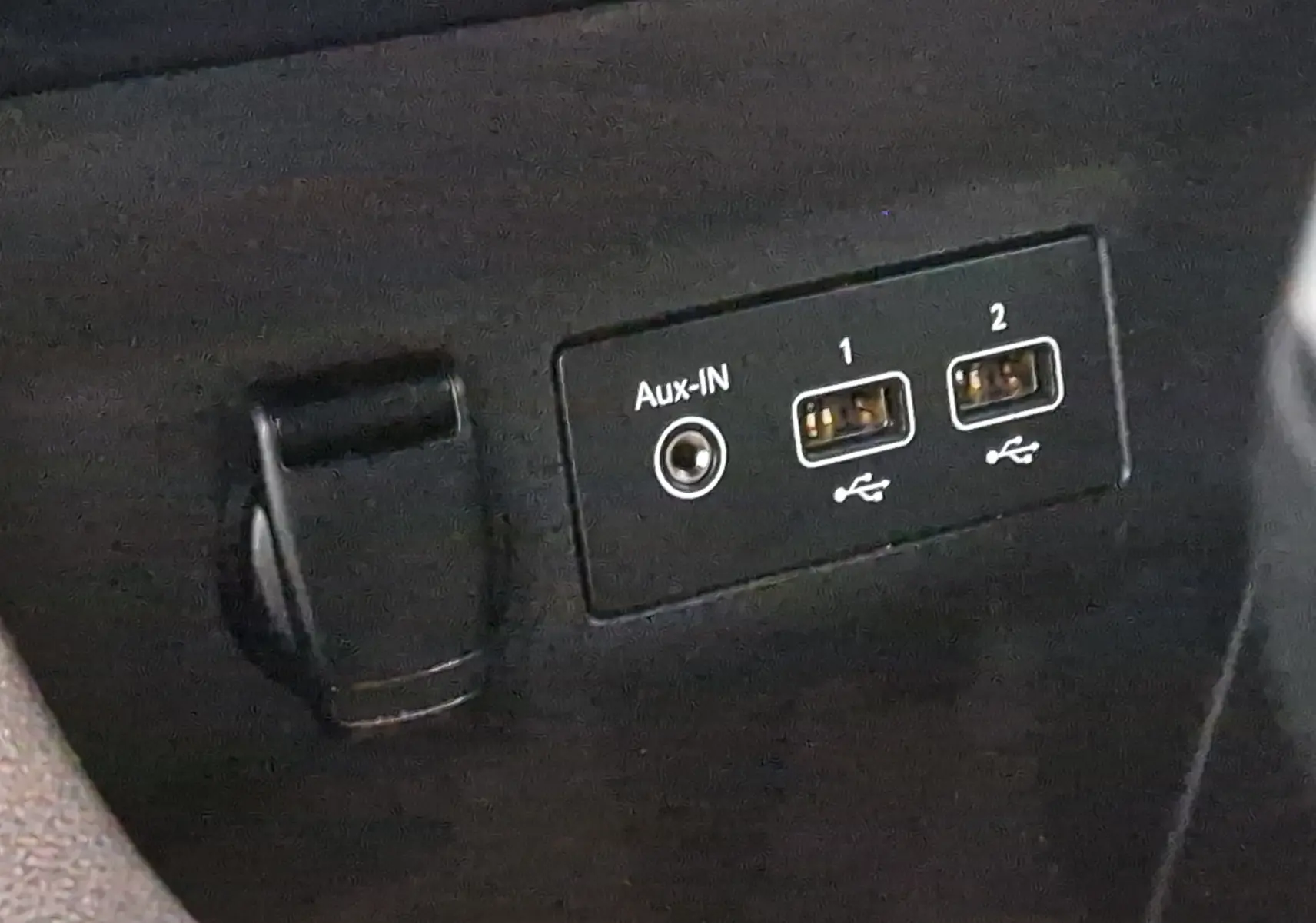 Prise auxiliaire et deux ports USB visibles sur la console centrale d'une Renault Clio V gris platine, version Zen.