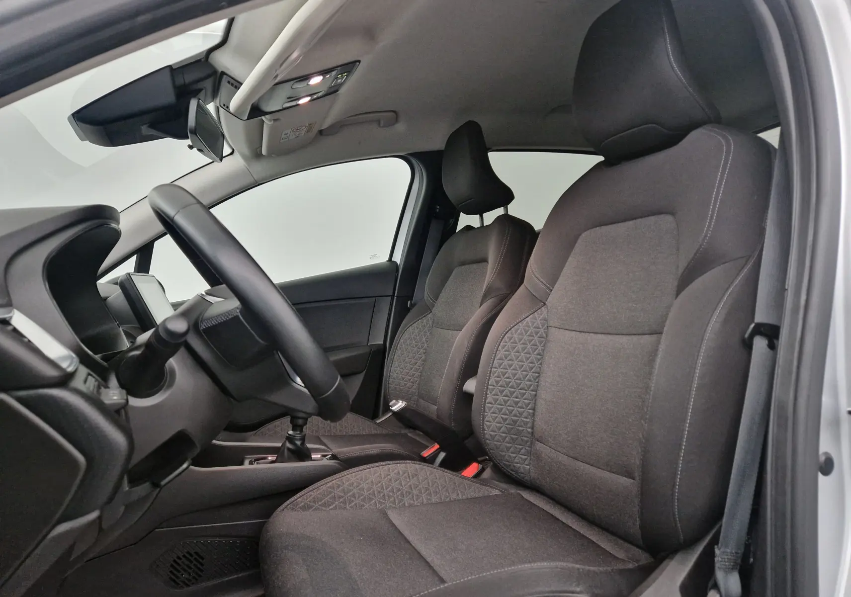 Intérieur avant de la Renault Clio V 1.0 TCE 90 Zen 2021, sièges tissu gris et volant côté gauche visible.