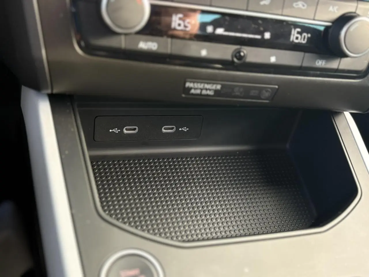 Gros plan sur la console centrale noire du SEAT Arona 2024, montrant deux ports USB-C et commandes climatisation.