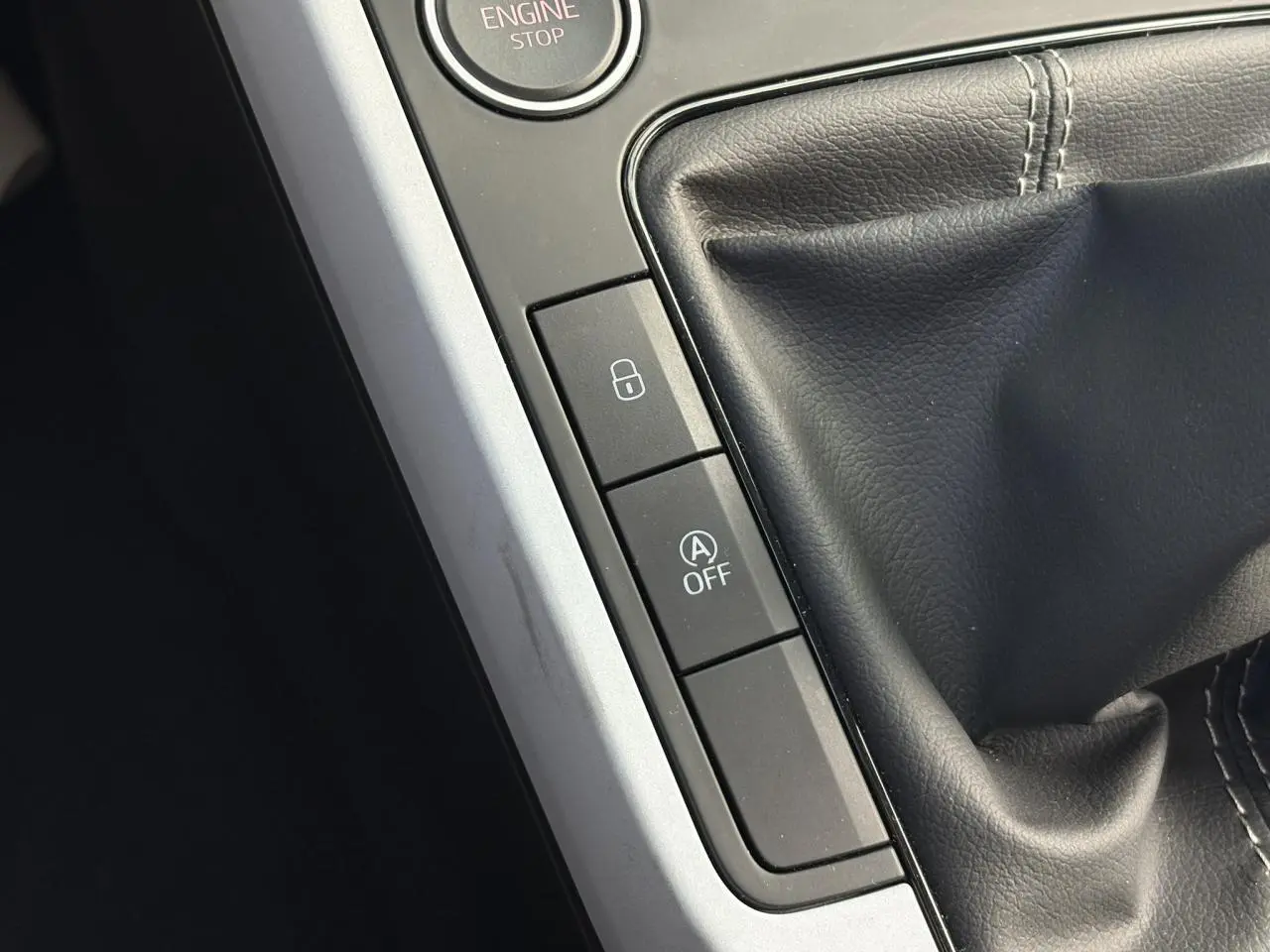 Gros plan sur la console centrale du SEAT Arona 2024 montrant le levier de vitesses manuel et les boutons de verrouillage et arrêt auto start-stop.