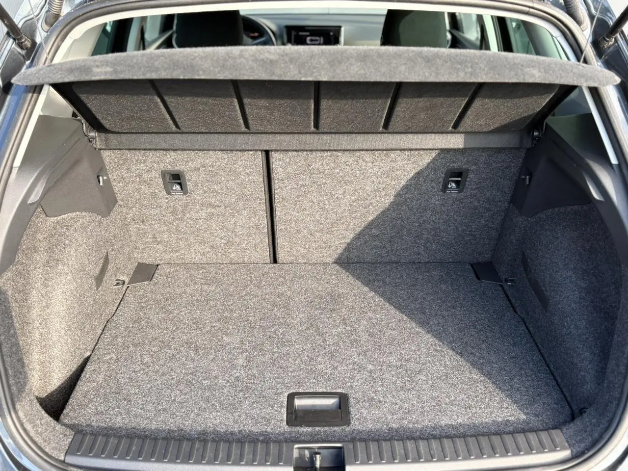 Coffre ouvert d'une SEAT Arona gris magnétique, montrant l'espace de chargement et les fixations ISOFIX arrière.