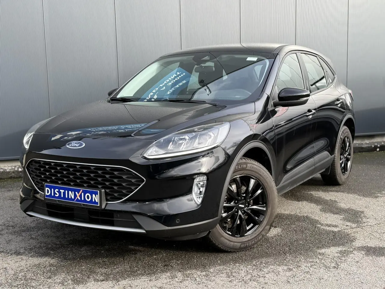 Ford Kuga 2024 noir Obsidien en 3/4 avant droit, avec jantes alliage noires et calandre distinctive.