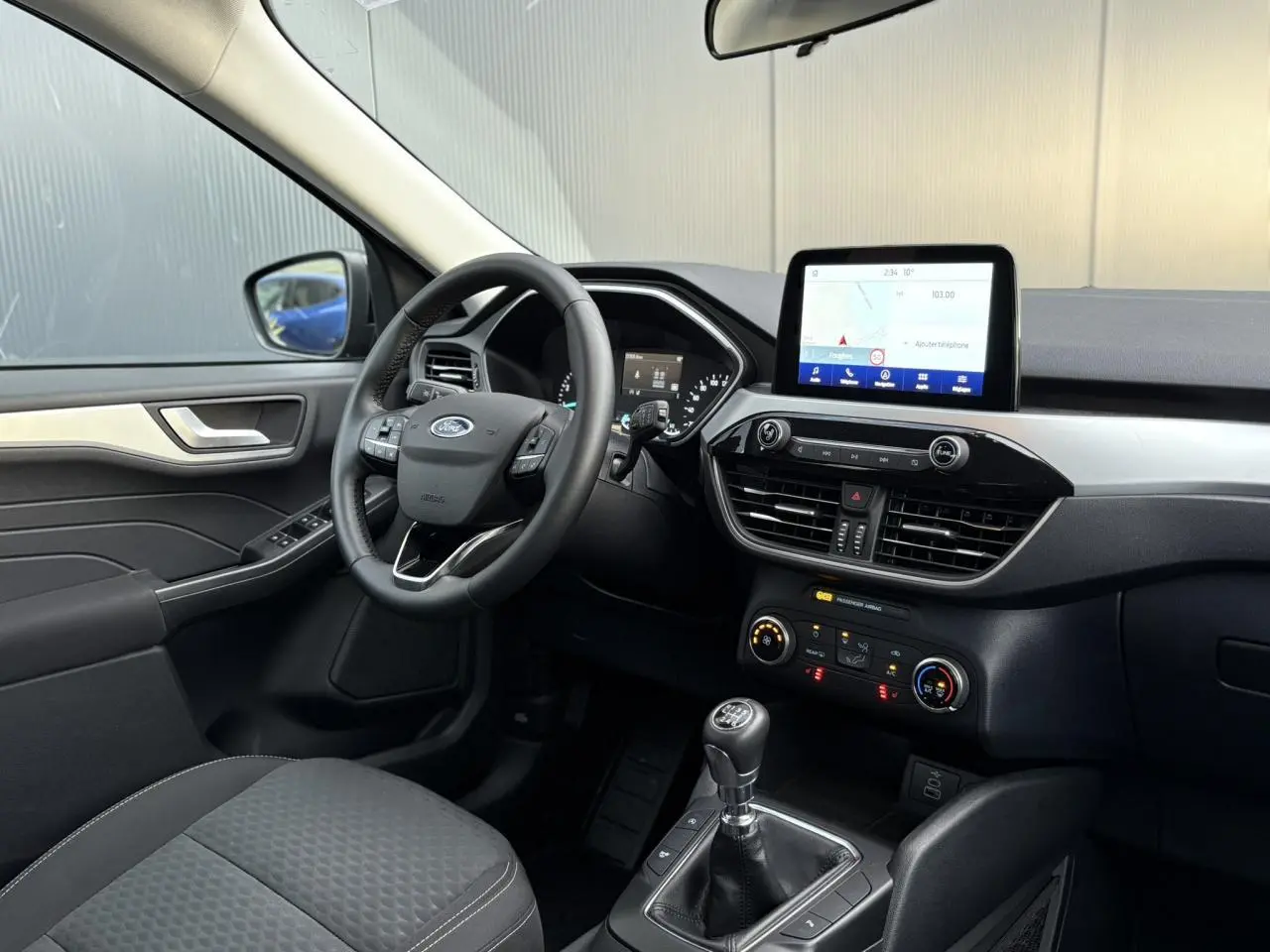 Vue intérieure côté conducteur du Ford Kuga 2024 noir Obsidien, avec tableau de bord moderne et écran tactile GPS.