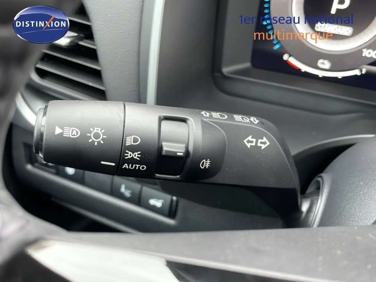 Gros plan sur la commande des feux et clignotants du Nissan Qashqai blanc nacré, intérieur côté gauche.