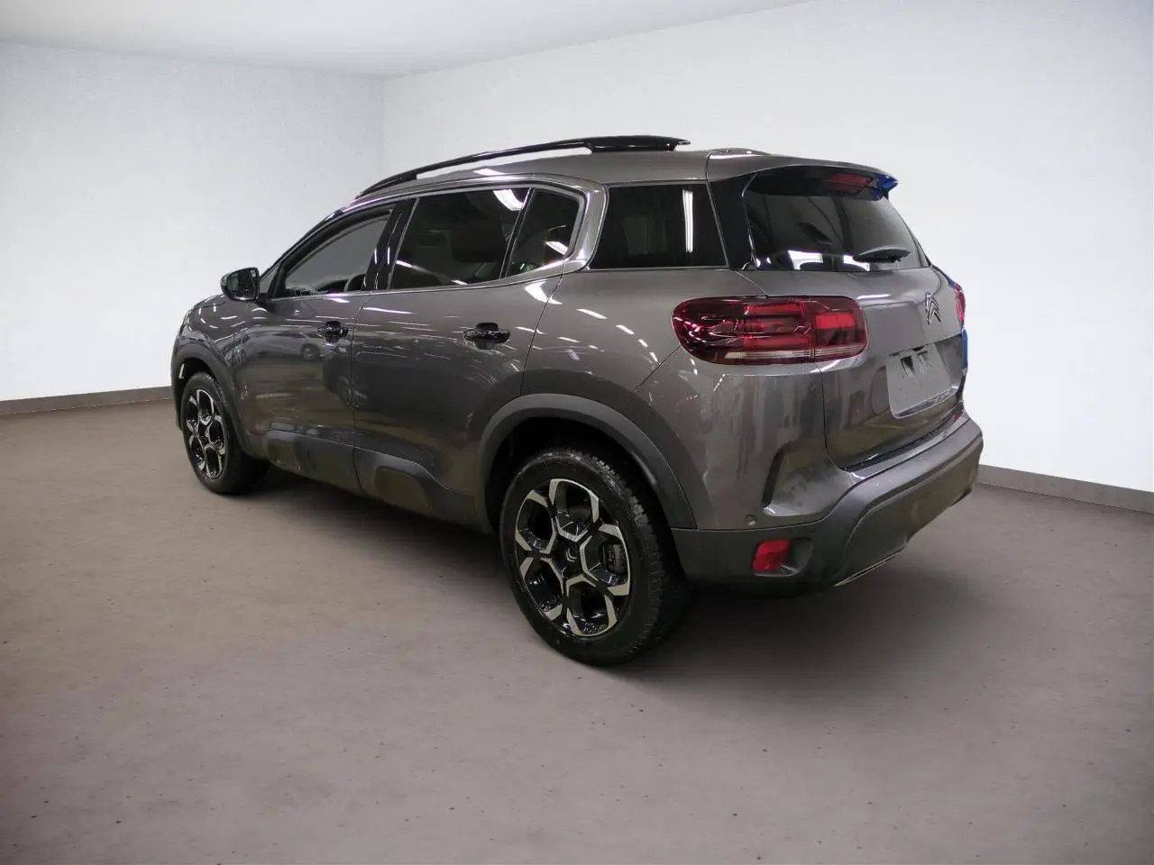 Vue 3/4 arrière droite du Citroën C5 Aircross Hybrid gris Platinium avec jantes alliage bi-ton et vitres teintées.