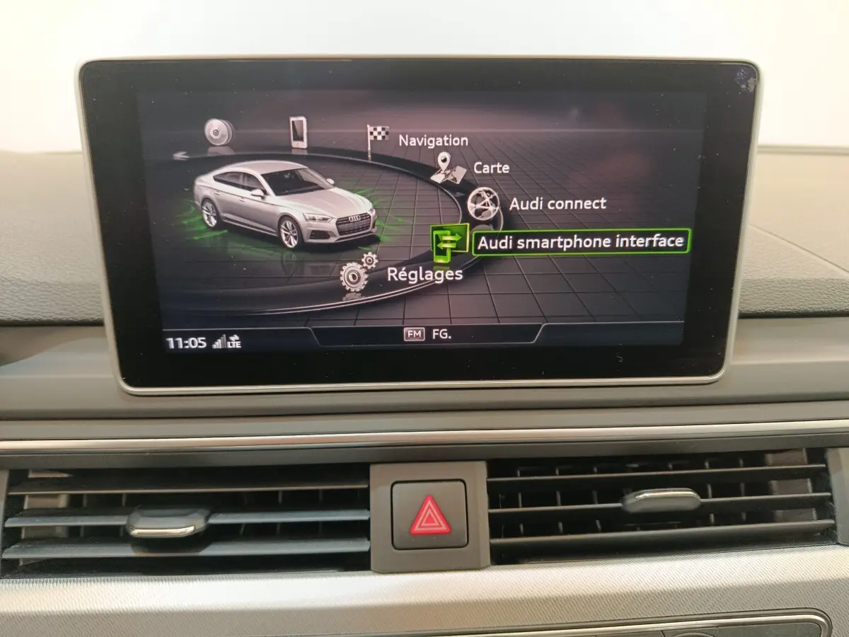 Écran central affichant le menu multimédia avec une Audi A5 gris clair en vue 3/4 avant stylisée.