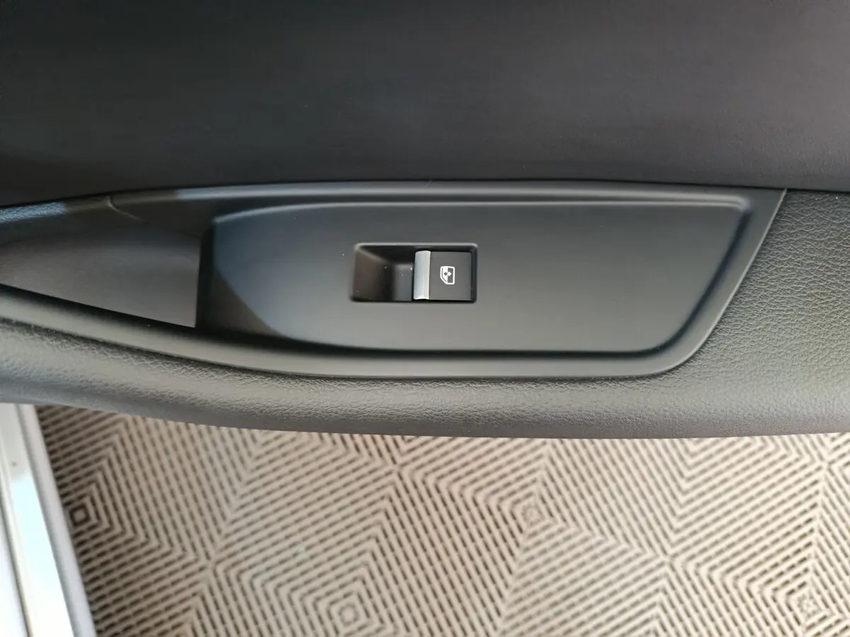 Bouton de commande de lève-vitre électrique sur la porte intérieure côté conducteur, plastique noir mat.