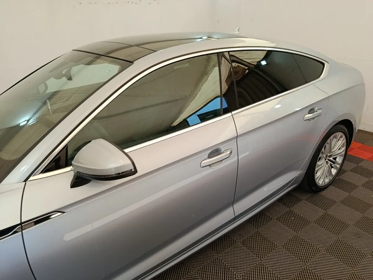 Vue latérale droite d'une Audi A5 gris clair avec vitres teintées et jantes alliage multibranches.