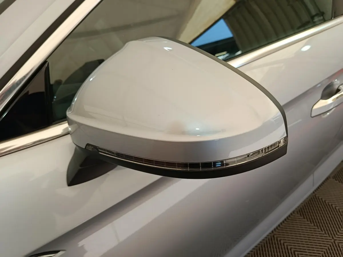 Rétroviseur droit gris clair d'Audi A5 2019 avec clignotant intégré, vue rapprochée sur la portière côté droit.
