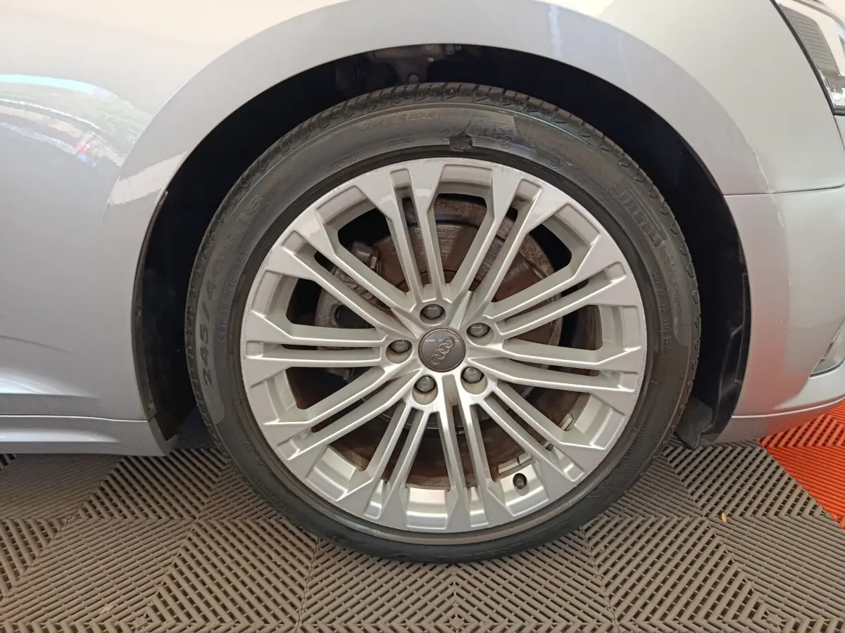 Gros plan sur la roue avant droite gris clair d'une Audi A5 40 TFSI 2019 avec jante alliage multi-branches.