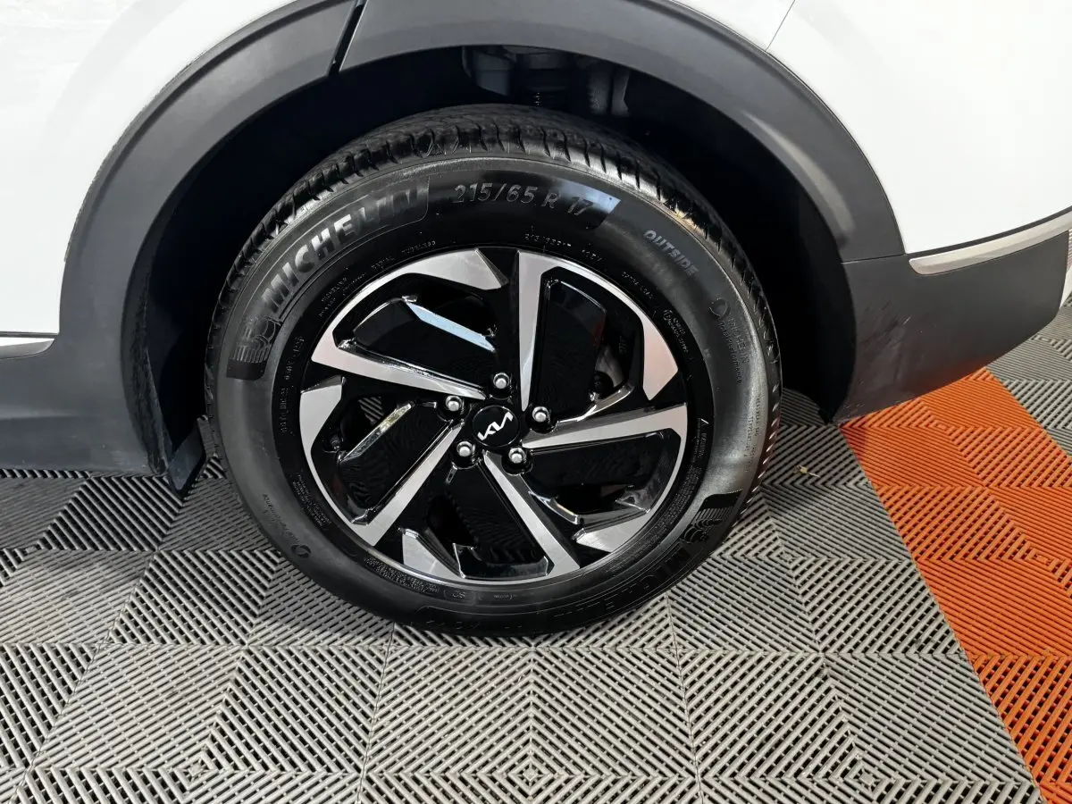 Gros plan sur la roue arrière droite du KIA Sportage blanc 2024 avec jante alliage bicolore et pneu Michelin.