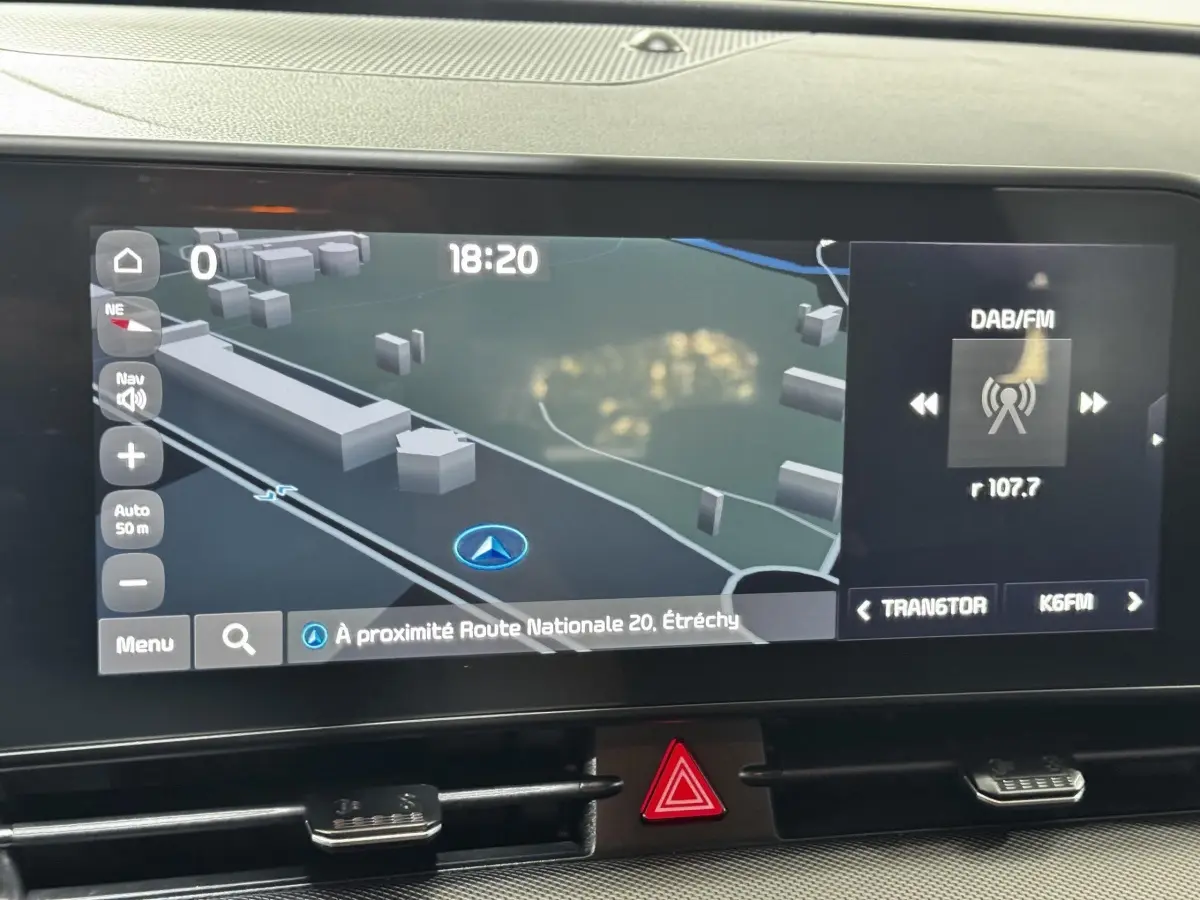Écran tactile central du Kia Sportage blanc 2024 affichant la navigation et la radio DAB/FM.