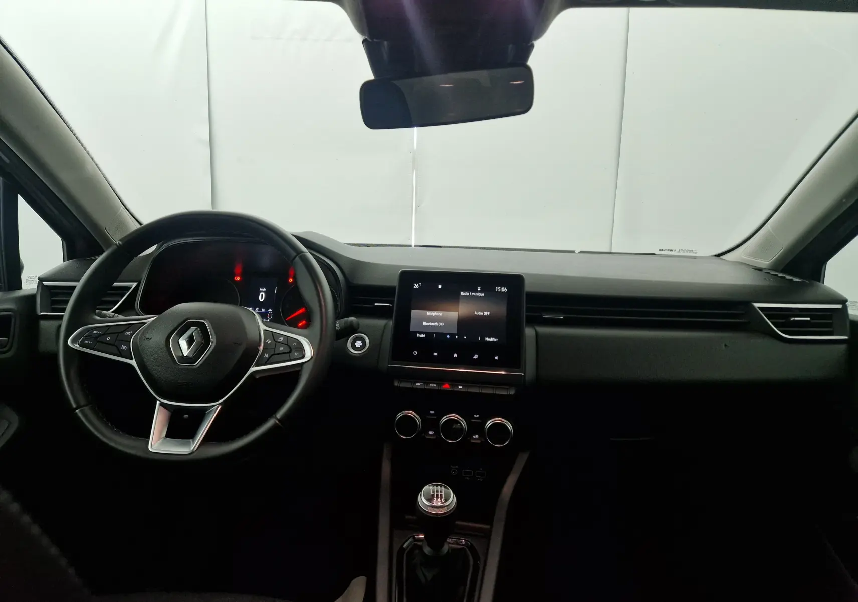 Intérieur de la Renault Clio V gris platine, vue frontale du tableau de bord avec volant et écran tactile central.