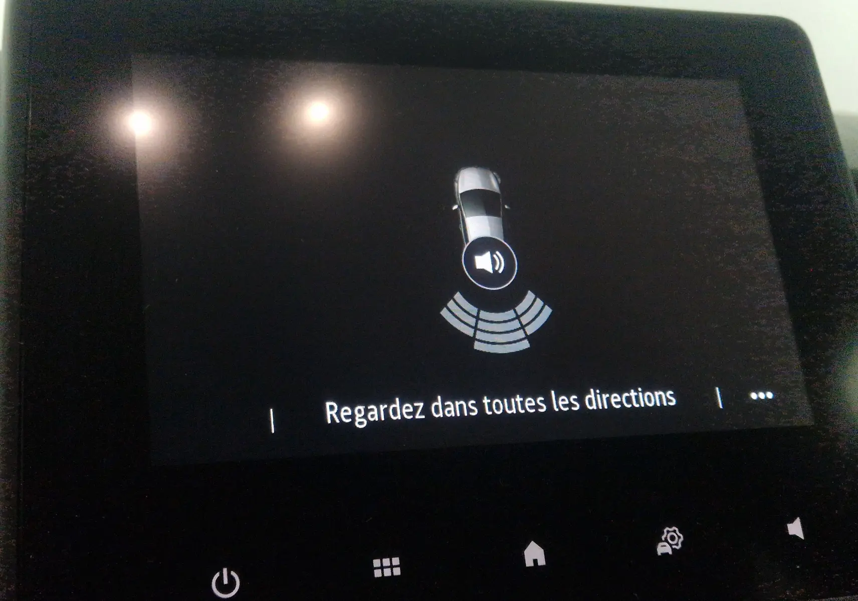 Écran tactile intérieur de Renault Clio V gris platine affichant l'alerte de proximité avec message "Regardez dans toutes les directions".