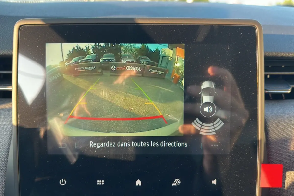 Écran de caméra de recul de la Renault Clio gris rafale 2025, affichant l'image arrière avec guidage coloré.
