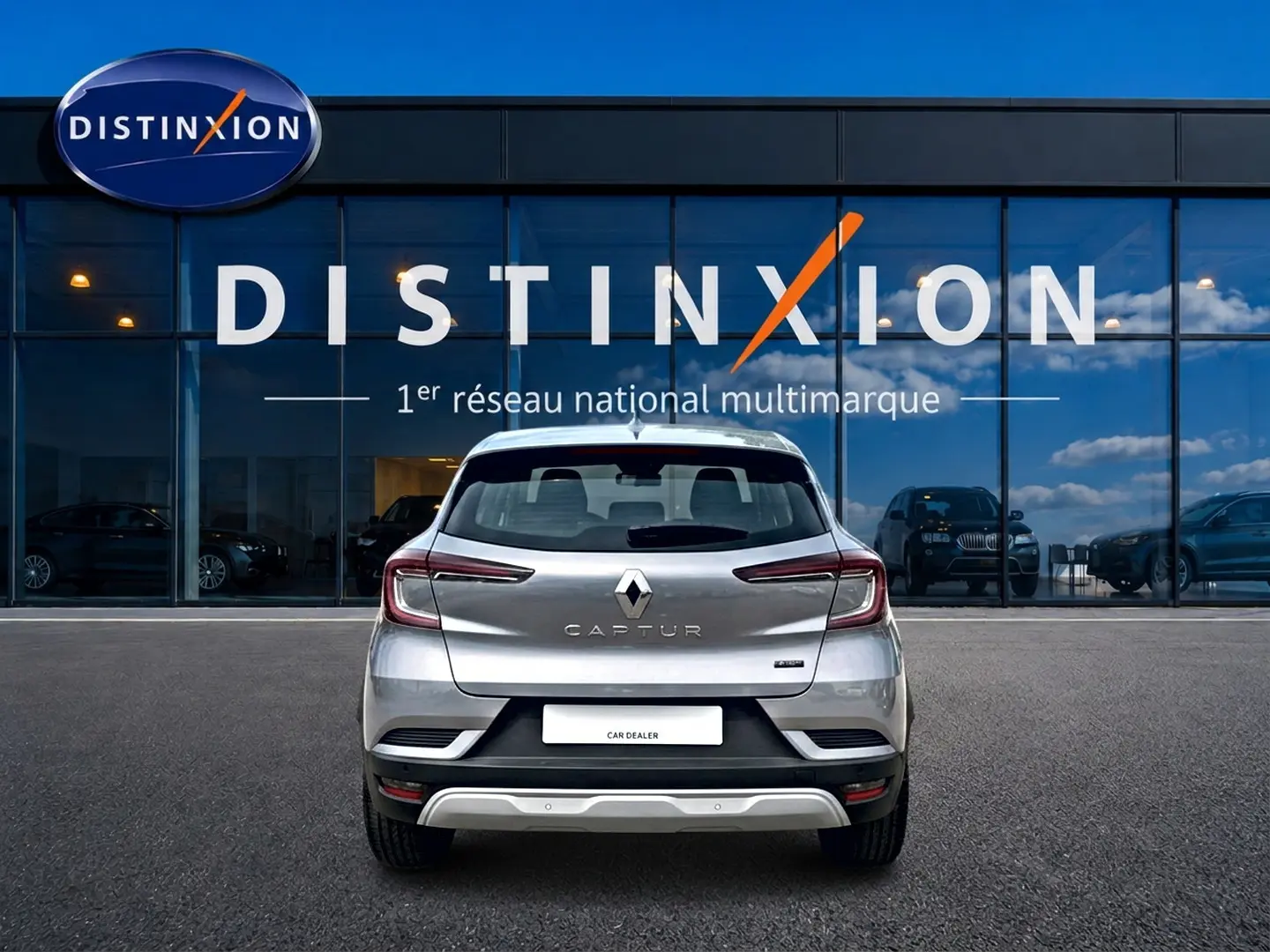 Vue arrière d'un Renault Captur 2026 gris cassiope avec toit noir, garé devant une vitrine Distinxion.