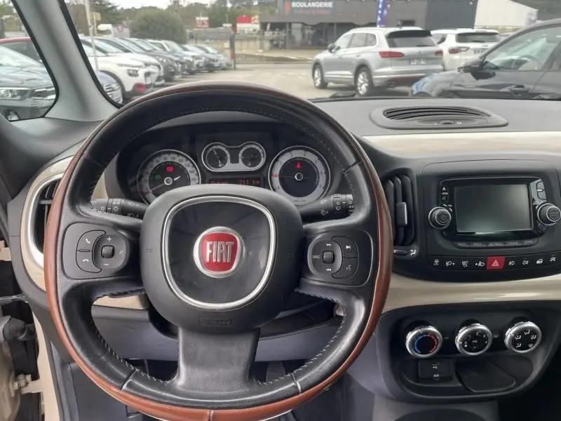 Vue intérieure du tableau de bord et volant cuir marron du Fiat 500L beige 2014 version 1.6 Multijet Tekking.