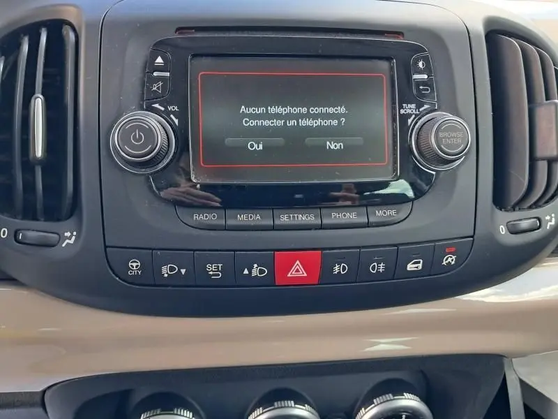 Vue rapprochée du tableau de bord beige d'une FIAT 500L 2014, avec écran central affichant la connexion téléphone.