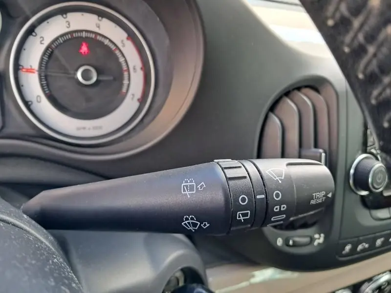 Gros plan sur la commande d’essuie-glace du tableau de bord d’une FIAT 500L beige de 2014, version Tekking.