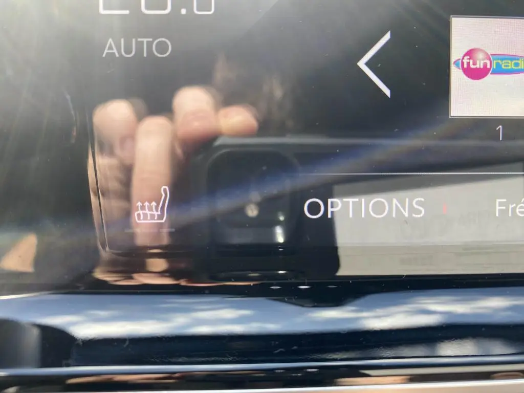 Gros plan sur l'écran tactile intérieur du DS7 Crossback jaune clair, affichant l'option sièges chauffants.