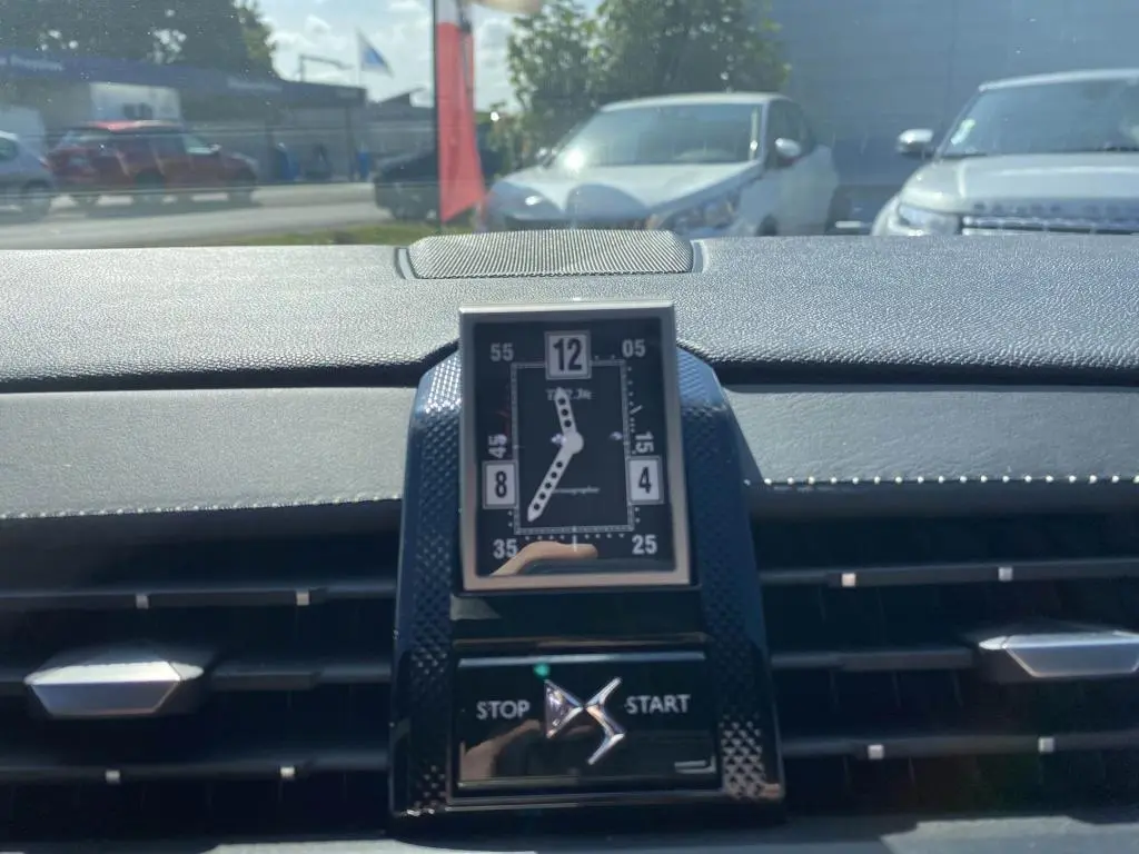 Gros plan sur l'horloge analogique centrale et le bouton stop/start du tableau de bord du DS7 Crossback, intérieur noir.