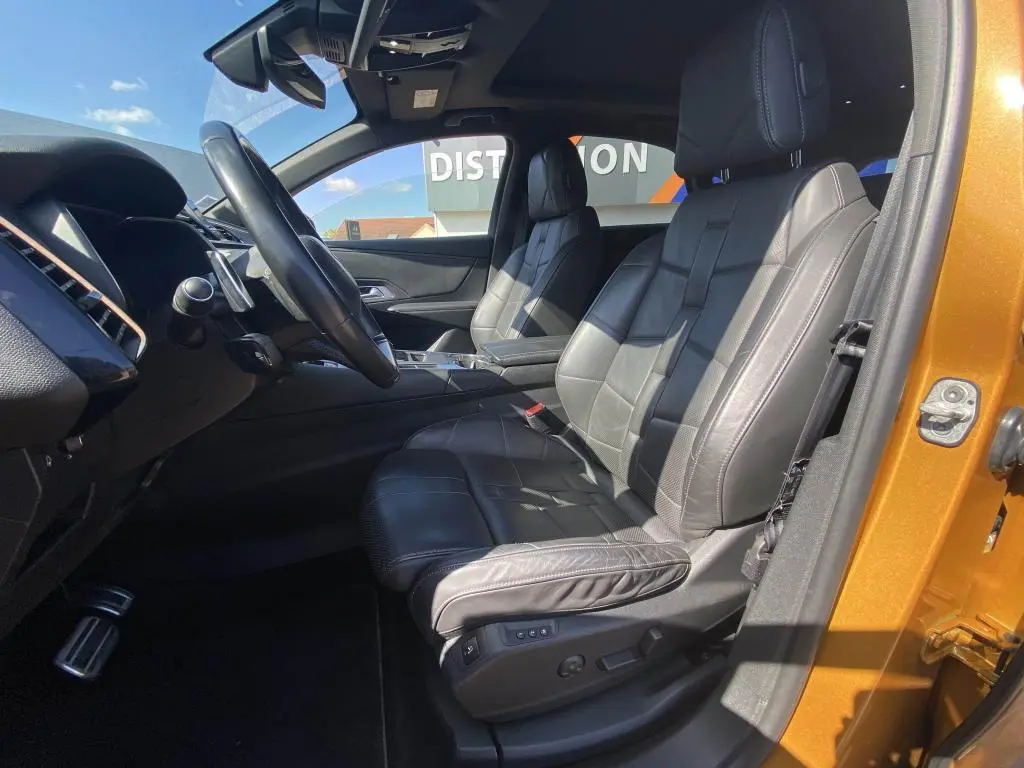 Vue intérieure côté conducteur du DS7 Crossback jaune clair, sièges cuir noir et toit ouvrant panoramique visible