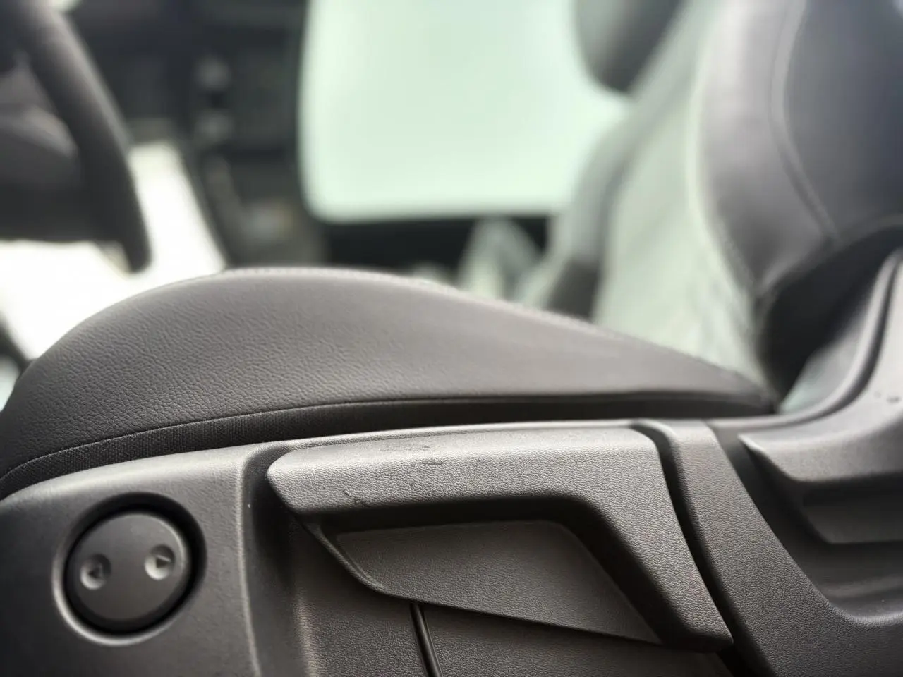 Détail de la commande de réglage du siège avant en cuir noir du Nissan Qashqai gris Ceramic 2025.