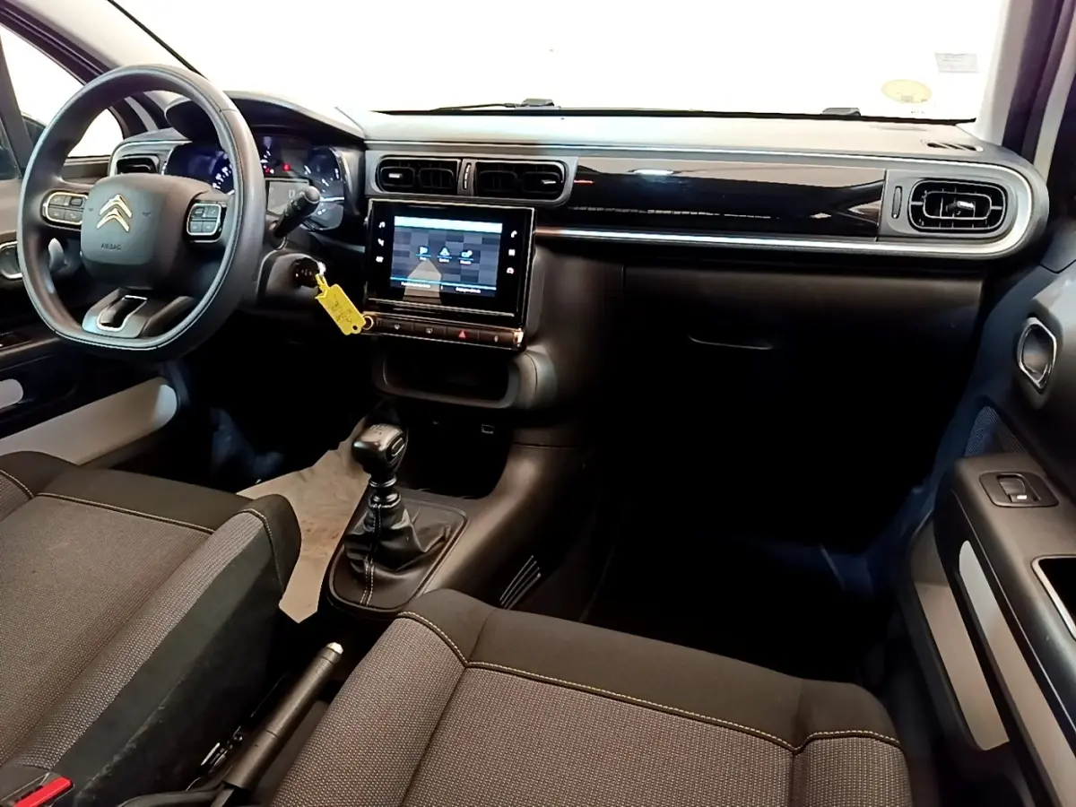 Intérieur noir de la Citroën C3 2022, vue de face côté conducteur avec tableau de bord et écran tactile central.
