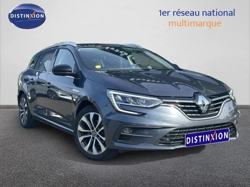 Renault Mégane Break gris titanium vue 3/4 avant avec jantes alu et calandre chromée distinctive.