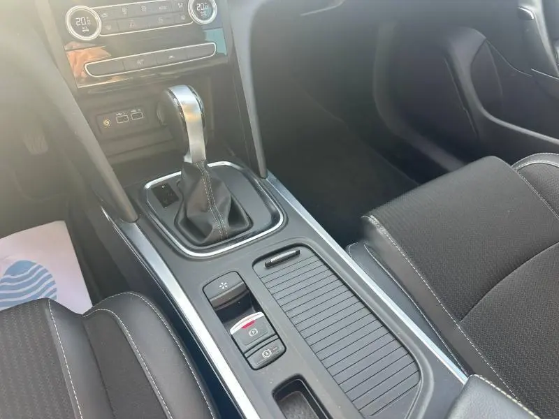 Vue intérieure rapprochée de la console centrale avec levier de boîte auto et accoudoir noir sur Renault Mégane Break 2024.